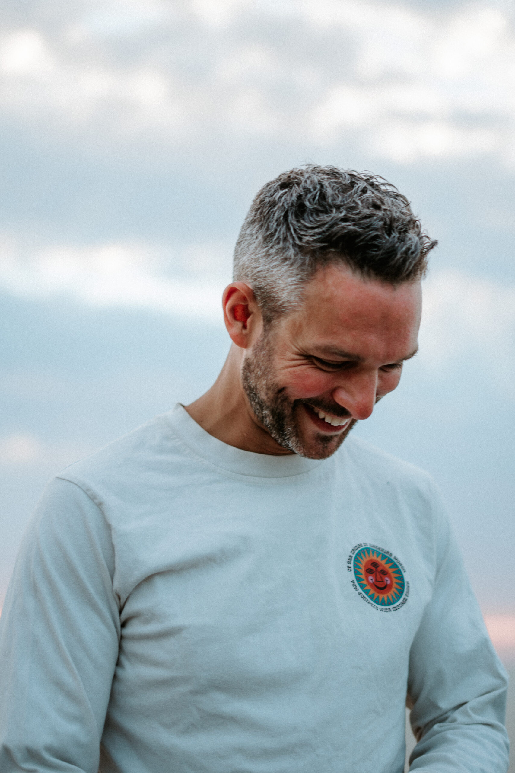 Margate headshot shoot for branding a business and empowering men in front of the lens with a man photographed at the beach in the sunset in a white long sleeve tee with the sky